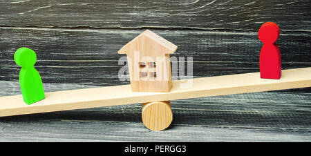 Figure in legno sulla bilancia il chiarimento di proprietà della casa, immobiliari. corte. rivali nell'azienda. concorrenza. la vittoria e la sconfitta. concep Foto Stock