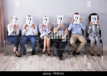 Persone azienda punto interrogativo segno davanti a loro volto Foto Stock