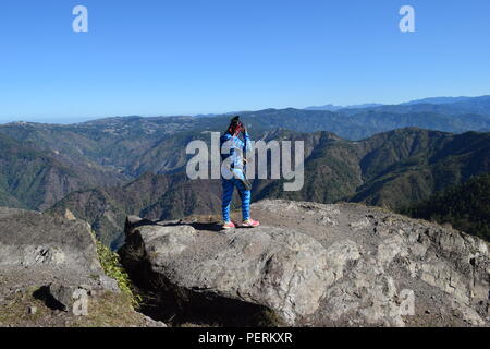 Una giovane ragazza Feytiri arrivati a Mount Ulap appoggio e recuperando dopo il lungo viaggio fino a terra e godersi il sorgere del sole all'alba in Ampucao Sta. Fe. Foto Stock