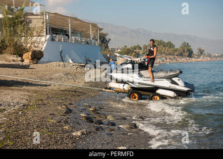 Jet ski su un rimorchio tirato fuori dall'acqua, San Pedro, Marbella, Spagna. Foto Stock