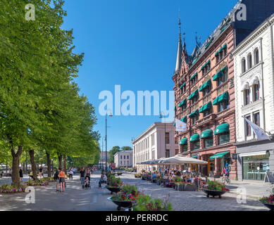 Caffetterie, bar, ristoranti e negozi a Karl Johans gate guardando verso l'Università di Oslo, Norvegia Foto Stock