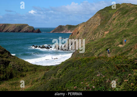 Due escursionisti sul sentiero costiero vicino Marloes sands beach e Gateholm isola con il mare ad alta marea Pembrokeshire West Wales UK KATHY DEWITT Foto Stock