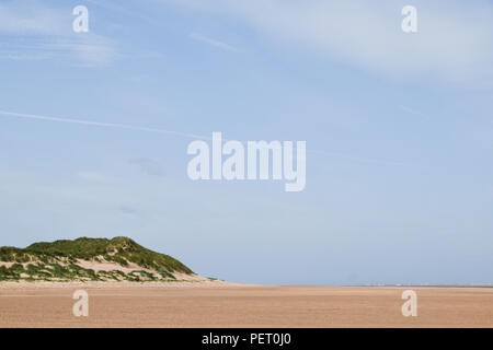 La spiaggia a Barrow-in-Furness sotto i cieli blu in Cumbria, nord-ovest dell'Inghilterra, Regno Unito. Foto Stock