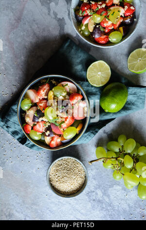 Una sana insalata di frutta con la quinoa, fragola, pesca, uva bianca, prugne, menta e miele medicazione di lime Foto Stock