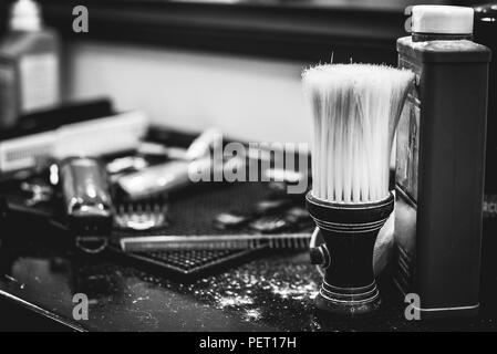 Spazzola per la rasatura barba lungo con ciotola, sfondo sfocato di parrucchiere per uomo, barbiere Foto Stock