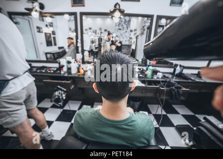 Fiducioso ragazzo seduto al salone di bellezza . Uomo taglio di capelli. Soft focus. Foto Stock