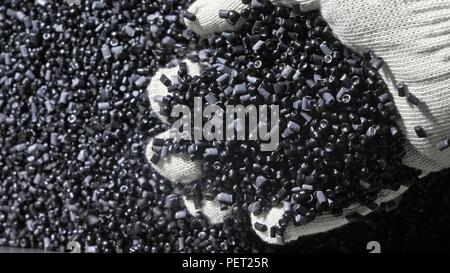 In plastica grigio nero granulato briciola. Fabbricazione di plastica tubazioni acqua fabbrica. Processo per la fabbricazione di tubi di plastica sulla macchina utensile con l uso dell acqua e la pressione dell'aria. Foto Stock