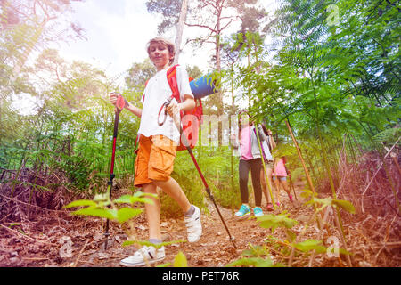 Ritratto di un ragazzo con zaino camminando tra amici in escursionismo attività su vacanze estate Foto Stock