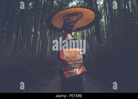 Bella giapponese donna senior passeggiate nella foresta di bamboo