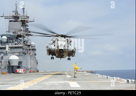 180815-N-PQ745-149 OCEANO PACIFICO (Agosto 15, 2018) Capo di aviazione di Boatswain Mate (movimentazione) Robert Pesce, segnali pilota di un CH-53E Super Stallion assegnato alle Marine elicottero pesante Squadron (HMH) 465, sul ponte di volo di assalto anfibio nave USS Boxer (LHD 4) durante le operazioni di volo. Boxer in corso è di condurre le operazioni di routine nell'Oceano Pacifico orientale. (U.S. Foto della marina da capo la comunicazione di massa specialista Justin L. Webb/rilasciato) Foto Stock