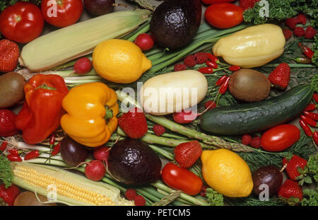 Composizione mista di verdure e frutta fresche tra cui peperoni, cetrioli, limoni, ravanelli, pomodori, mais, fragole, lamponi e avocado. Foto Stock