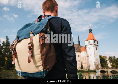 Un turista con lo zaino guarda le attrazioni turistiche. Il castello chiamato Blatna nella Repubblica ceca è sfocata in background. Vacanze, Viaggi Foto Stock