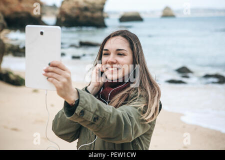 Una giovane donna turistico o blogger comunica sul tablet tramite Internet o storie comunicherà i suoi abbonati su ciò che sta accadendo. Foto Stock