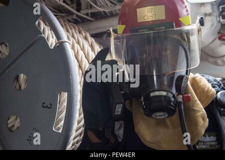 160129-N-ZZ786-065 sul Mare del Sud della Cina (GEN. 29, 2016) Boatswain compagno del marinaio Demarcus Lawrence, dal Porto Arthur, Texas, colloqui su una radio durante un incendio simulato durante un quartier generale praticare a bordo della Ticonderoga-class guidato-missili cruiser USS Antietam (CG 54). Antietam è di pattuglia nel 7 ° Flotta area di operazioni a sostegno della sicurezza e della stabilità in Indo-Asia-Pacifico. (U.S. Foto di Marina di Massa lo specialista di comunicazione di terza classe David Flewellyn/rilasciato) Foto Stock