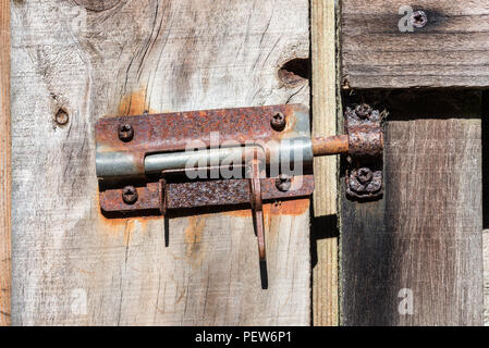 Rusty Lock sul legno della porta del granaio Foto Stock