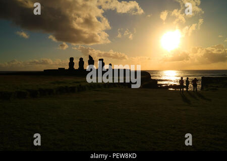 Guardare la gente bel tramonto sull'oceano Pacifico a Ahu Tahai con Moai statue, Isola di Pasqua del Cile, sito archeologico Foto Stock