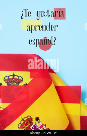 Alcune bandiere della Spagna e la questione te gustaria aprender espanol? Vuoi imparare lo Spagnolo? Scritto in spagnolo, su uno sfondo blu Foto Stock