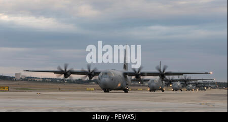 Stati Uniti Air Force C-130 Hercules e Super Hercules aerei cargo da più unità taxi per la pista per una linea statica parachute drop a sostegno delle operazioni di airdrop durante il grande pacchetto Settimana sul Papa Army Airfield, N.C., 6 febbraio 2016. Grande pacchetto Settimana è una derivazione fino a operative comuni di esercizio di accesso 16-5 che prepara l'esercito dell'aria e unità di forza a livello mondiale per una crisi e le operazioni di emergenza. (U.S. Air Force Photo by Staff Sgt. Gregorio Brook) Foto Stock