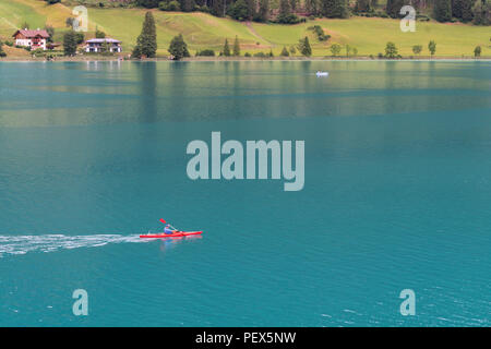 Un uomo con una canoa nel lago Weissensee, Austria Foto Stock