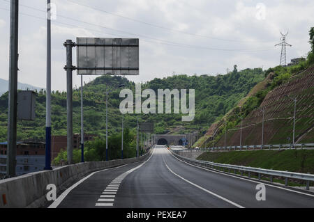 La strada che conduce al tunnel attraverso una montagna Foto Stock