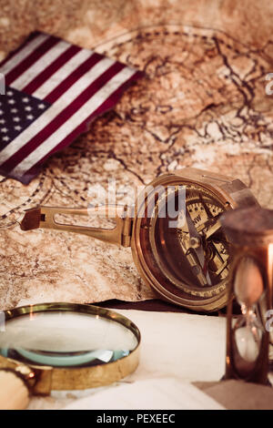 Vecchio vintage mappe e attrezzature marine come bussola, alla lente di ingrandimento o la clessidra e nave. Il Columbus Day concetto. Foto Stock