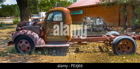 TAOS, NM, Stati Uniti d'America-8 luglio 18: due vecchi camion e una fattoria carro, impostazione al di fuori della Freccia Rossa Emporium. Foto Stock