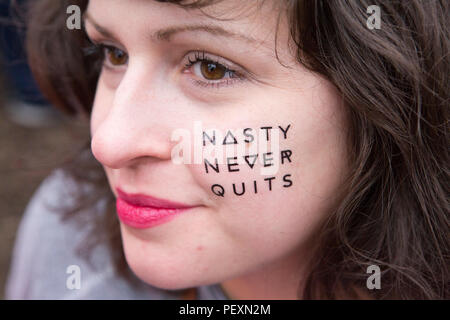 Donna con dipinta sul testo sul volto di donna di marzo Foto Stock