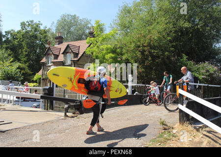 Un maschio Canoeist, due maschi adulti e due bambini su biciclette guarda una barca con il blocco. Hertford serratura, fiume Lea, Hartham comune, Hertford Herts. Foto Stock