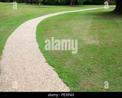 Piuttosto curvo sentiero di ghiaia nel giardino privato della grande casa di campagna in Inghilterra. Proprietà rilasciato. Foto Stock