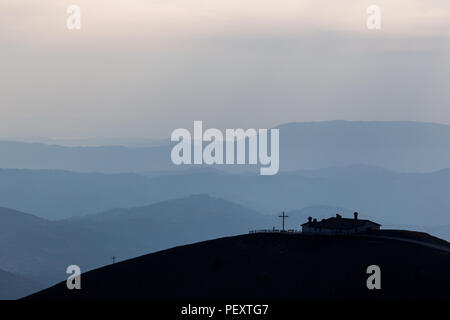 Vista del Serrasanta hermitage (Umbria, Italia) sulla cima di una montagna, con vari altri strati di montagne in background Foto Stock