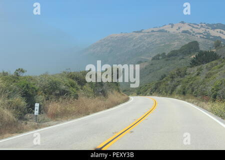 Piegare in autostrada a sinistra nella nebbia Foto Stock