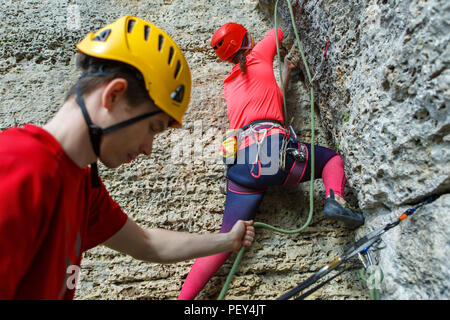 Foto di donna arrampicata su roccia e istruttore maschio Foto Stock