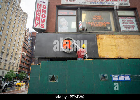 Un lavoratore rimuove il segno di RadioShack da una posizione chiusa nel quartiere di Chelsea di New York lunedì, 13 agosto 2018. HobbyTown negozi sono dalla costruzione di RadioShack Express memorizza in un negozio a 100 posizioni. Questa particolare posizione è presto diventato un Taco Bell Cantina! (Â© Richard B. Levine) Foto Stock