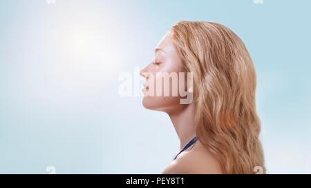 Donna in presenza di luce solare con gli occhi chiusi. Foto Stock