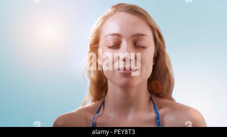 Donna in presenza di luce solare con gli occhi chiusi. Foto Stock