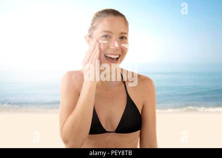 Donna l'applicazione di crema solare per il viso. Foto Stock