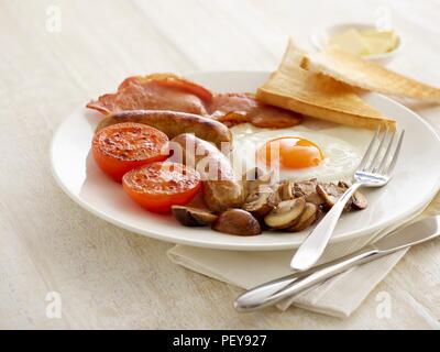 La completa prima colazione inglese è servita su una piastra. Foto Stock