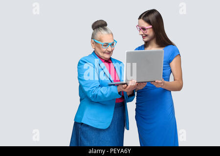 Nonna felice di istruzione o di donna per lavorare in social networking. nipote cercando di insegnare la sua nonna per uso portatile e lavorare su internet. i Foto Stock