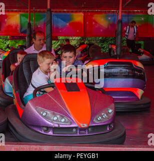 I bambini di equitazione dodgems o del paraurti di automobili su una fiera ride. Foto Stock