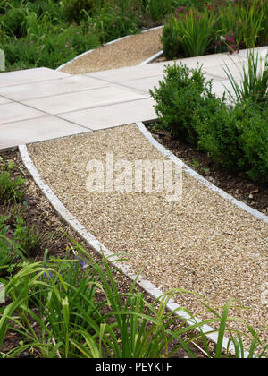 Moderno di lastre di pietra percorsi di formazione intorno a un giardino formale area di un paese inglese home. Proprietà rilasciato Foto Stock