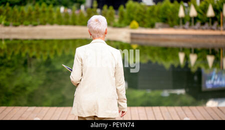 Chiudere Indietro in alto consente di visualizzare la foto della donna elegante passeggiando sul marciapiede nel parco Foto Stock