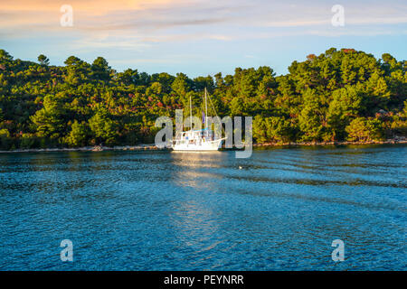 Una barca a vela yacht moors off sull isola vicino a Hvar, Croazia in un pomeriggio autunnale sulla costa dalmata. Foto Stock