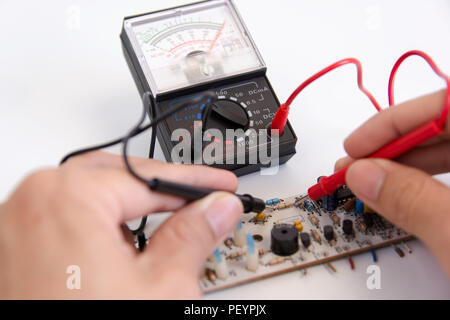 Manuale tecnico con sonde del multimetro riparazione scheda di circuito Foto Stock