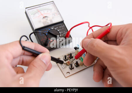 Manuale tecnico con sonde del multimetro riparazione scheda di circuito Foto Stock
