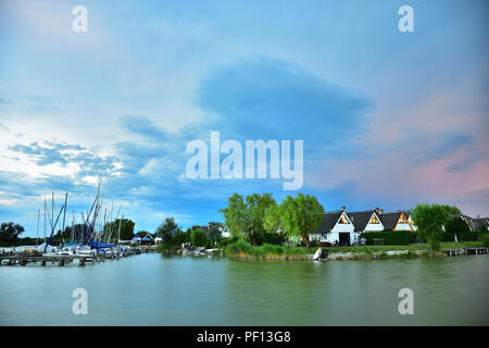 Atmosfera serale con storm cloud su un insediamento cottage a lago Neusiedlersee nel Burgenland, Austria. Foto Stock