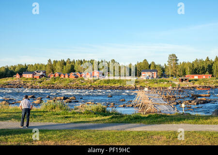 Turista gode la vista da Kukkola in Svezia attraverso il fiume Torne verso la Finlandia. Kukkola rapids è stato un sito di pesca sin dal medioevo Foto Stock