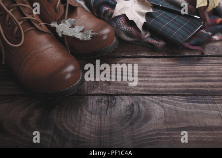 Traveler's stivali accessori plaid e notepad sul vecchio fienile Sfondo legno Foto Stock