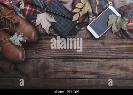 Traveler del fotografo di accessori stivali plaid telefono mobile e il Blocco note sul vecchio fienile Sfondo legno Foto Stock