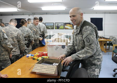 Stati Uniti Esercito Col. Christopher Selvey, il vice comandante per la trentesima Armored Brigade Combat Team e multinazionale Group-East battaglia, i soldati aiuta a trascorrere il tempo volontariamente imballaggio forniture scolastiche come parte di una comunità iniziativa di outreach, Dicembre 9, 2015, a Camp Bondsteel in Kosovo. (U.S. Esercito foto di Sgt. Erick Yates, multinazionale battaglia Group-East) Foto Stock