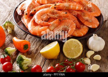 Bollito di gamberi tigre su una piastra e verdure fresche close-up su una tavola orizzontale. Foto Stock